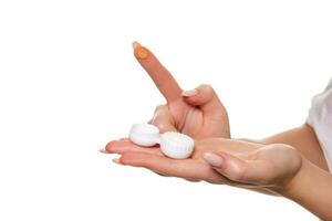 Contact eye lens. Close-up of woman hands holding white eye lense container. Woman fingers holding eye lense box. photo