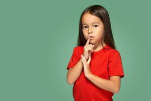 niña colocación dedo en labios preguntando shh, tranquilo, silencio foto