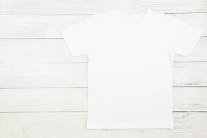 White womens cotton tshirt mockup on wooden background. Design t shirt template, print presentation mock up. Top view flat lay. photo