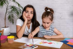 Happy family. Mother and daughter together paint. photo