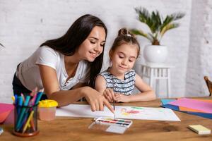 Happy family. Mother and daughter together paint. photo