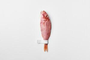 One salted air-dried surmullet with label on tail on white background photo