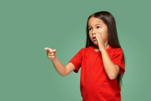 joven niña en rojo camiseta es temeroso de alguna cosa foto