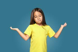 Surprised girl with spread arms on blue background photo