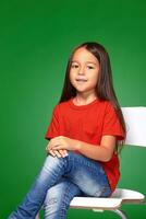 little girl wearing red t-short and posing on chair photo