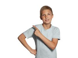 Close-up portrait of a blonde teenage boy in a white t-shirt posing isolated on white studio background. Concept of sincere emotions. photo