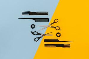 Hairdresser tools on blue and yellow background with copy space, top view, flat lay. photo