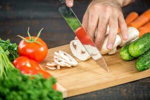 Male hands cutting vegetables for salad photo