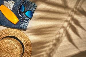 Summer background with straw hat, sunglasses, sunscreen bottle and flip flops photo