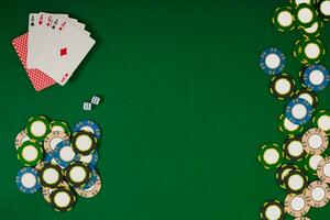 different color chips for gamblings and playing cards on green photo