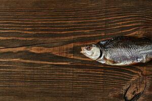 uno seco o espasmódico salado cucaracha, sabroso clipfish en de madera antecedentes. salado cerveza aperitivo. tradicional camino de conservación pez. cerca arriba foto