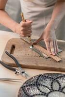 Artist cutting sheets of stained glass into small mosaic squares. Close-up photo