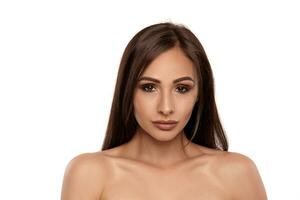 Close up portrait of a brunette nude model girl with professional evening make-up and plump lips, posing isolated on white background. photo