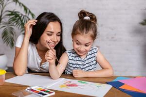 Happy family. Mother and daughter together paint. photo