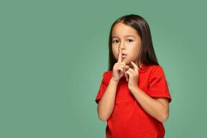 niña colocación dedo en labios preguntando shh, tranquilo, silencio foto