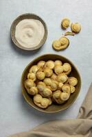 Puff pastry eyelet, Palmier cookies in a bowl with cinnamon and sugar on the light concrete background. Top view. photo