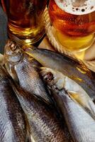 Closeup of salted air-dried roach fish, sabrefish and perch served with amber beer photo