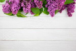 Beautiful spring lilac flowers on white wooden background. Valentines, womens, mothers day, easter, birthday, wedding or holiday flat lay. Top view. Copy space. photo