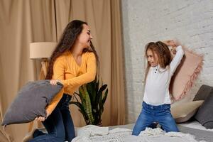 Mom and daughter fooling around with pillow fights photo
