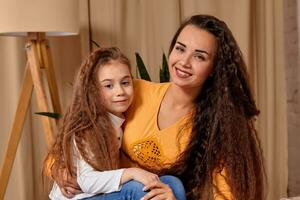 amor de joven madre y hija. ellos sentar en el cama a hogar y tener divertido foto