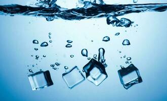 ice cubes falling down. ice cubes on blue background. splash on blue. ice cubes in water photo