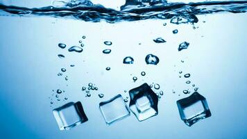 ice cubes falling down. ice cubes on blue background. splash on blue. ice cubes in water photo