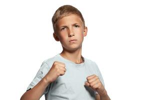 Close-up portrait of a blonde teenage boy in a white t-shirt posing isolated on white studio background. Concept of sincere emotions. photo