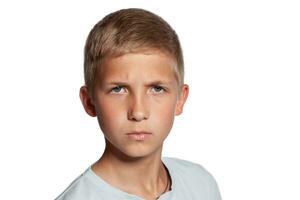 Close-up portrait of a blonde teenage boy in a white t-shirt posing isolated on white studio background. Concept of sincere emotions. photo