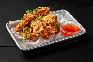 Crispy fried chicken wings in batter with sweet chili sauce photo