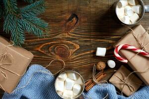 Cocoa with marshmallow, chocolate and spruce branches on a wooden background photo