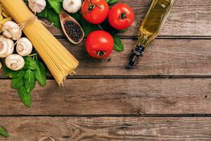 pasta y ingredientes en de madera antecedentes con Copiar espacio. parte superior vista. vegetariano alimento, sano o Cocinando concepto. foto