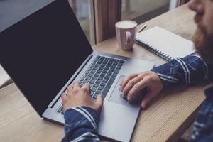 Cropped image of young man chatting via net-book during work bre photo