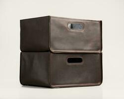 Two storage boxes of brown faux leather with slotted handles photo