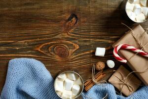 cacao con malvavisco, chocolate y abeto ramas en un de madera antecedentes foto