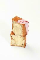 Cut in half cube shaped croissant with vanilla custard, berry icing and candied raspberry photo