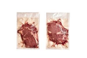 Unopened pack of 2 raw beef steaks isolated on white background. photo