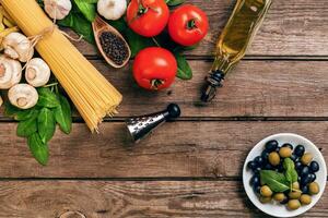 Pasta and ingredients on wooden background with copy space. Top view. Vegetarian food, healthy or cooking concept. photo