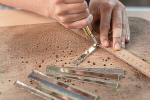 Artist cutting sheets of stained glass into small mosaic squares. Close-up photo