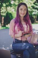 Woman writing in a notebook sitting on a wooden bench in the par photo