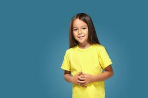 pequeño niña en amarillo camiseta es sonriente foto