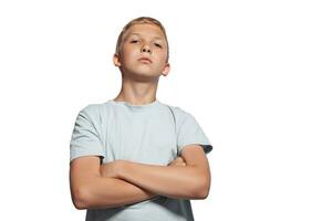 Close-up portrait of a blonde teenage boy in a white t-shirt posing isolated on white studio background. Concept of sincere emotions. photo