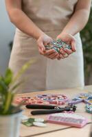 Workplace of the mosaic master women's hands holding mosaic details in the process of making a mosaic photo