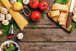 italiano comida tomates para cocinar, albahaca, pasta, aceituna petróleo y queso en de madera fondo, parte superior vista, Copiar espacio. foto