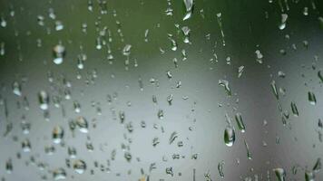 gotas de lluvia corredizo en un ventana mientras es lloviendo fuera de video