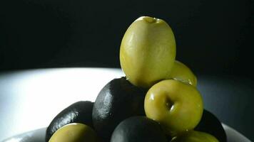 Olives fruit green and black gyrating on black background video