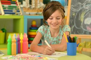 Portrait of cute girl drawing picture at home photo