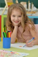 Portrait of cute girl drawing picture at home photo
