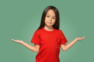 Surprised girl with spread arms isolated on green background photo