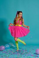 Lovely girl with a multi-colored braids hairstyle and bright make-up, posing in studio with air balloons and confetti against a blue background. photo