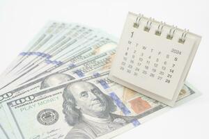 2024 Jan Calendar and US dollars. Pension Concept. Bonus Money. isolated on white background. photo